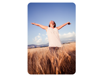 Woman standing in a field with her arms wide open