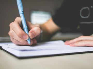 Picture of someone writing in a notebook