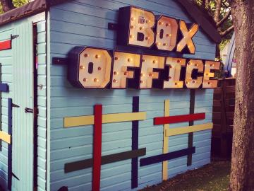 Blue and white striped shed with the words Box Office on it.