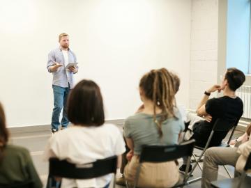 A person presenting to a room of people