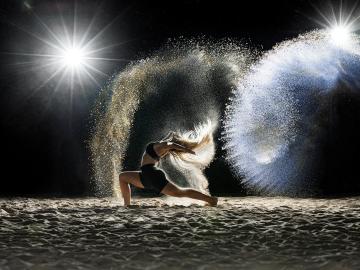 Dancer performing in the dark with shimmering lights