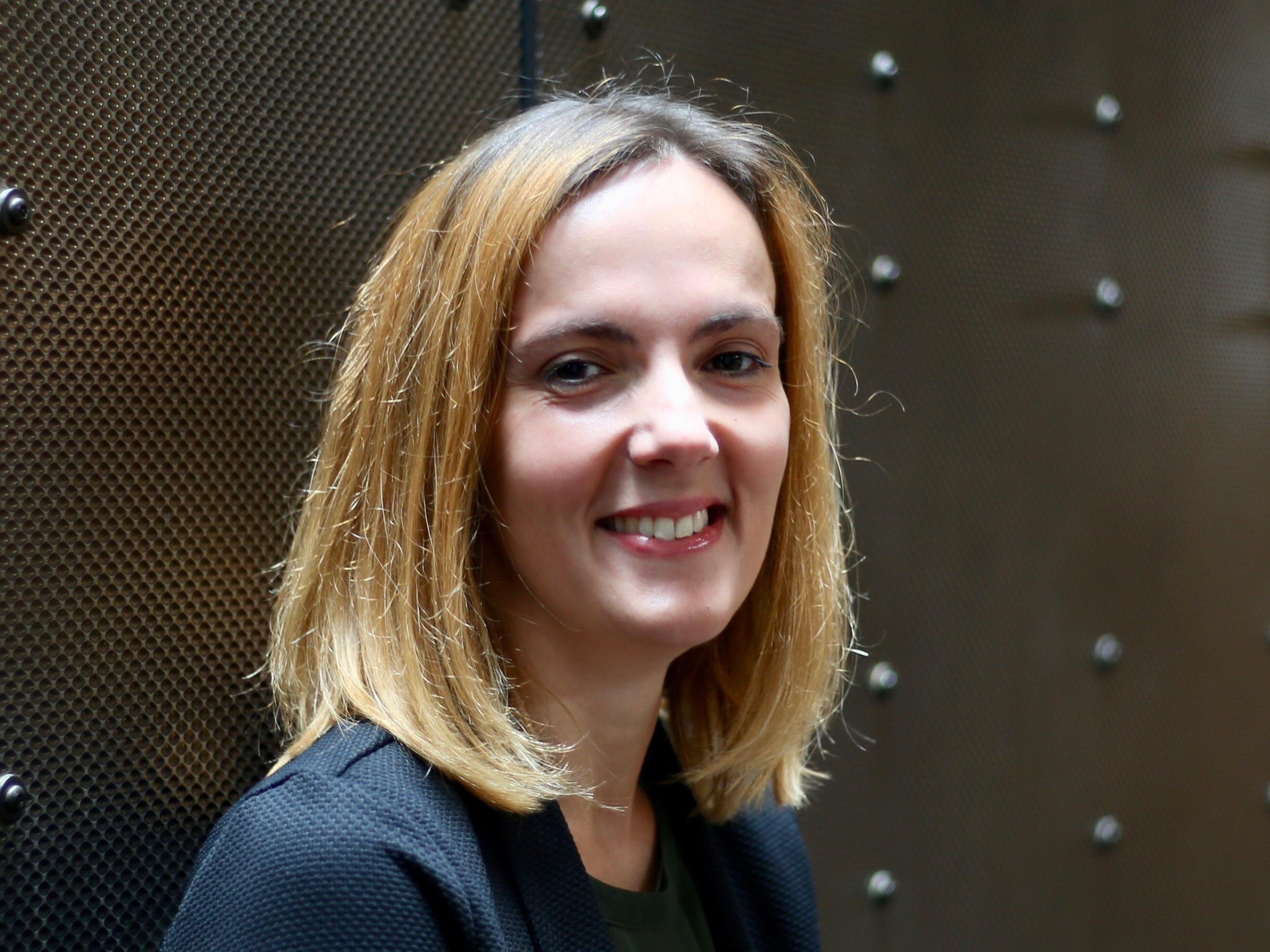 White woman with shoulder length brown hair smiling