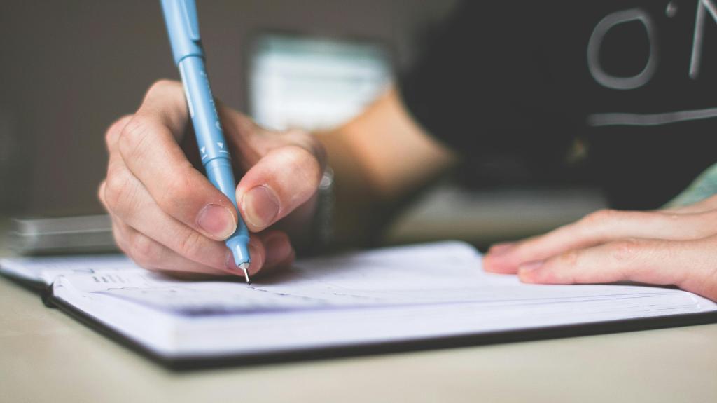 Picture of someone writing in a notebook