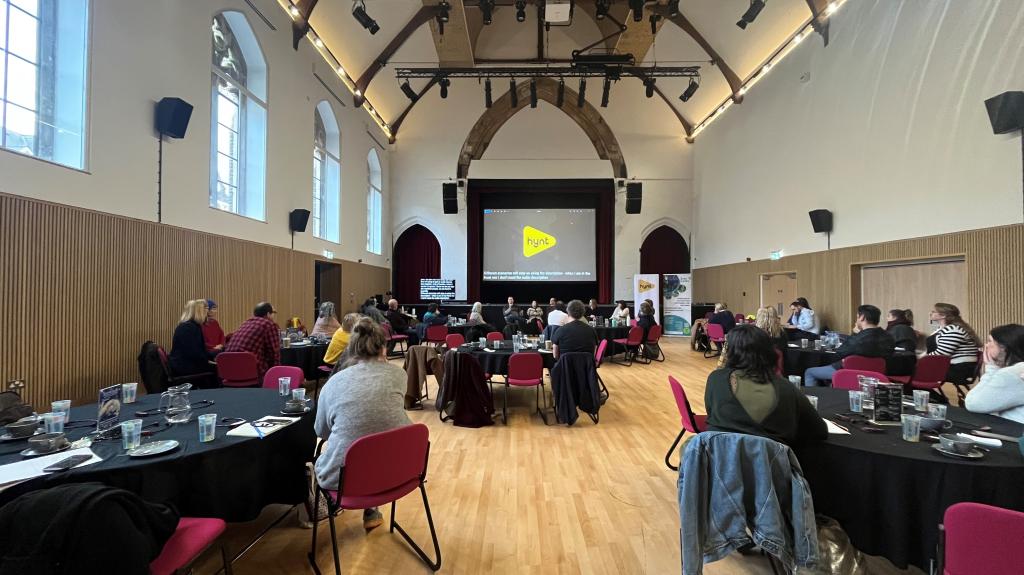 Image of people sat at tables at a Conference